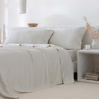 Juego de sábanas beige confeccionado con bambú orgánico de 300 hilos, compuesto por sábana encimera, bajera y fundas de almohada a juego, destacando la suavidad sedosa, la transpirabilidad, la regulación natural de la temperatura y el confort sostenible del tejido.