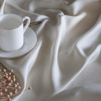 Ropa de cama beige de bambú orgánico de 300 hilos con tejido suave y regulación natural de la temperatura para un descanso reparador.