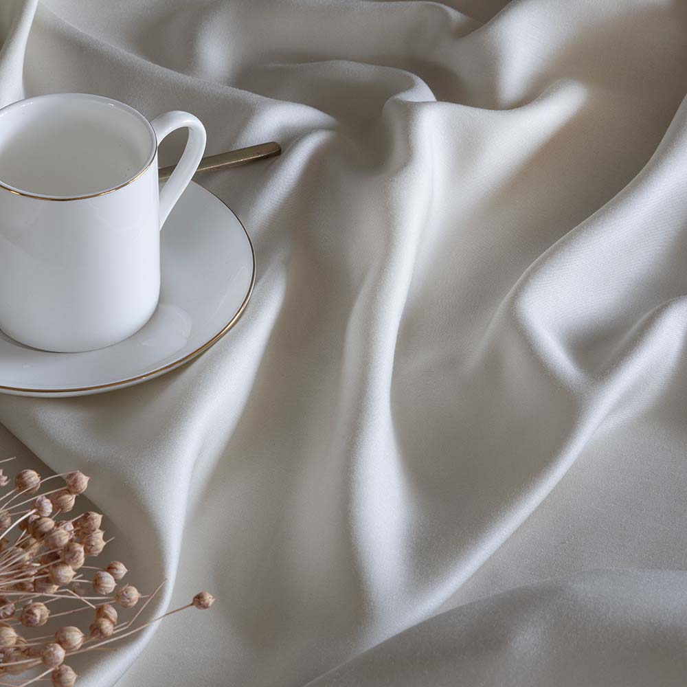 Ropa de cama beige de bambú orgánico de 300 hilos con tejido suave y regulación natural de la temperatura para un descanso reparador.