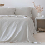 Sábana beige de bambú orgánico de 300 hilos con tacto sedoso, alta transpirabilidad y regulación natural de la humedad,  con decoración contemporánea y ambiente relajante, ideal para un descanso fresco, cómodo y sostenible.