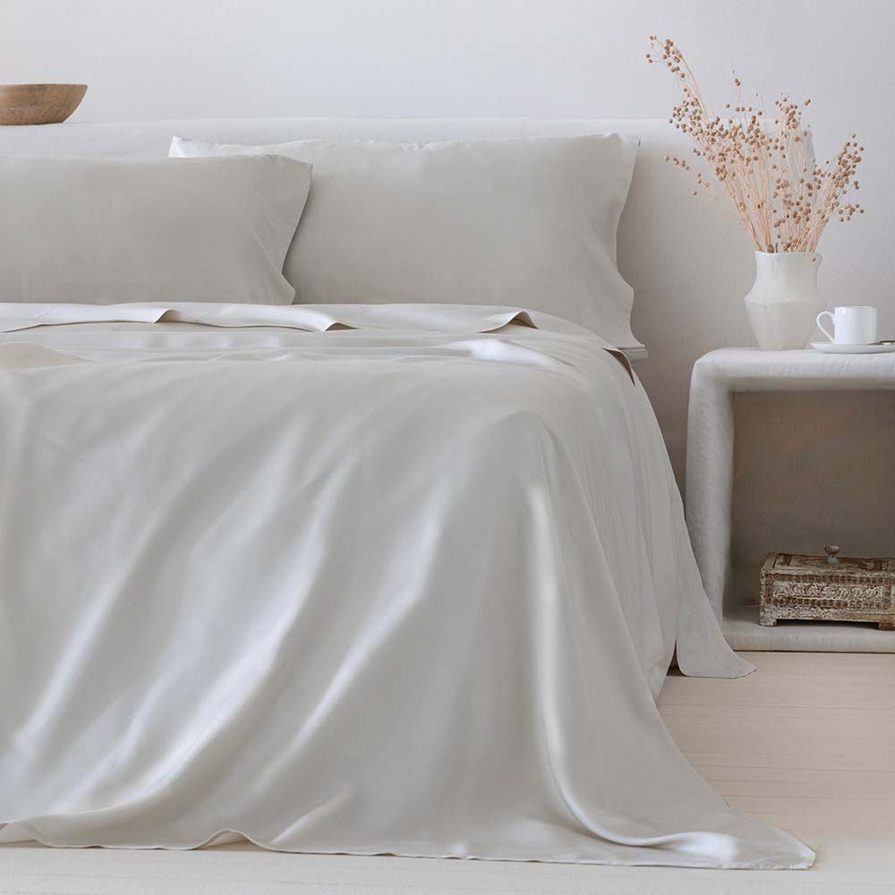 Sábana beige de bambú orgánico de 300 hilos con tacto sedoso, alta transpirabilidad y regulación natural de la humedad,  con decoración contemporánea y ambiente relajante, ideal para un descanso fresco, cómodo y sostenible.