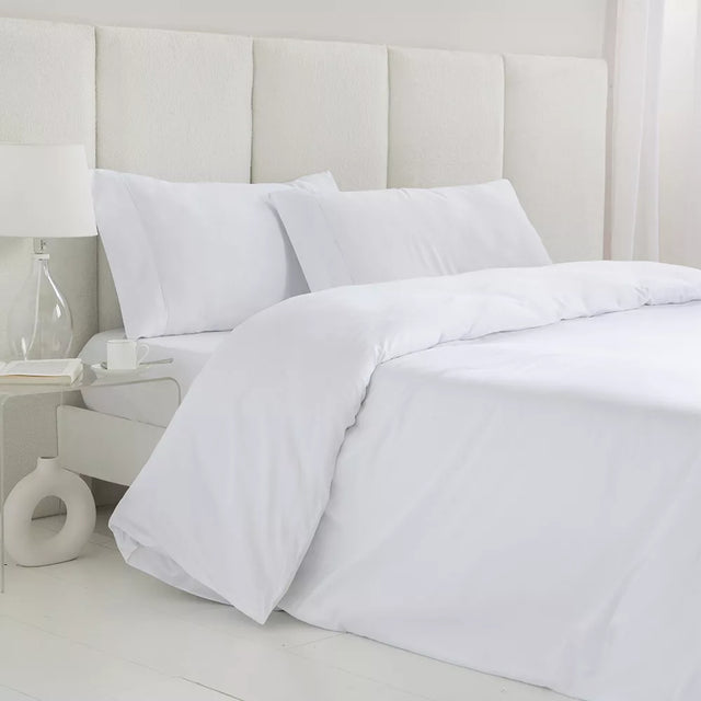 Juego de funda nórdica blanco de satén algodón egipcio de 300 hilos con sábana bajera ajustable y fundas de almohada sobre cama de dormitorio luminoso.