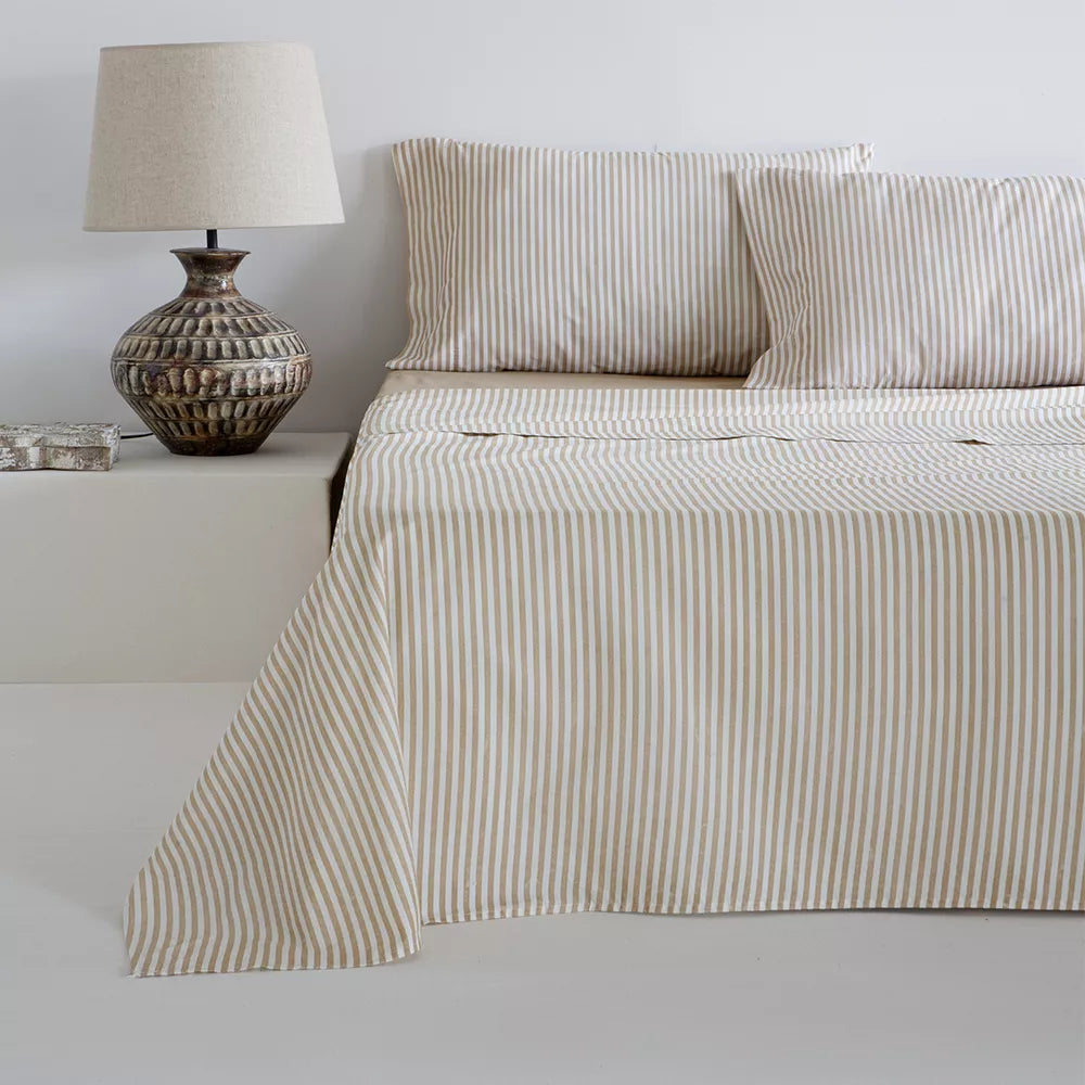 Sábana de algodón beige y mostaza con tejido suave, transpirable y resistente, presentada en una cama de matrimonio con decoración contemporánea y ambiente acogedor, ideal para aportar confort, calidez y estilo al dormitorio. a rayas