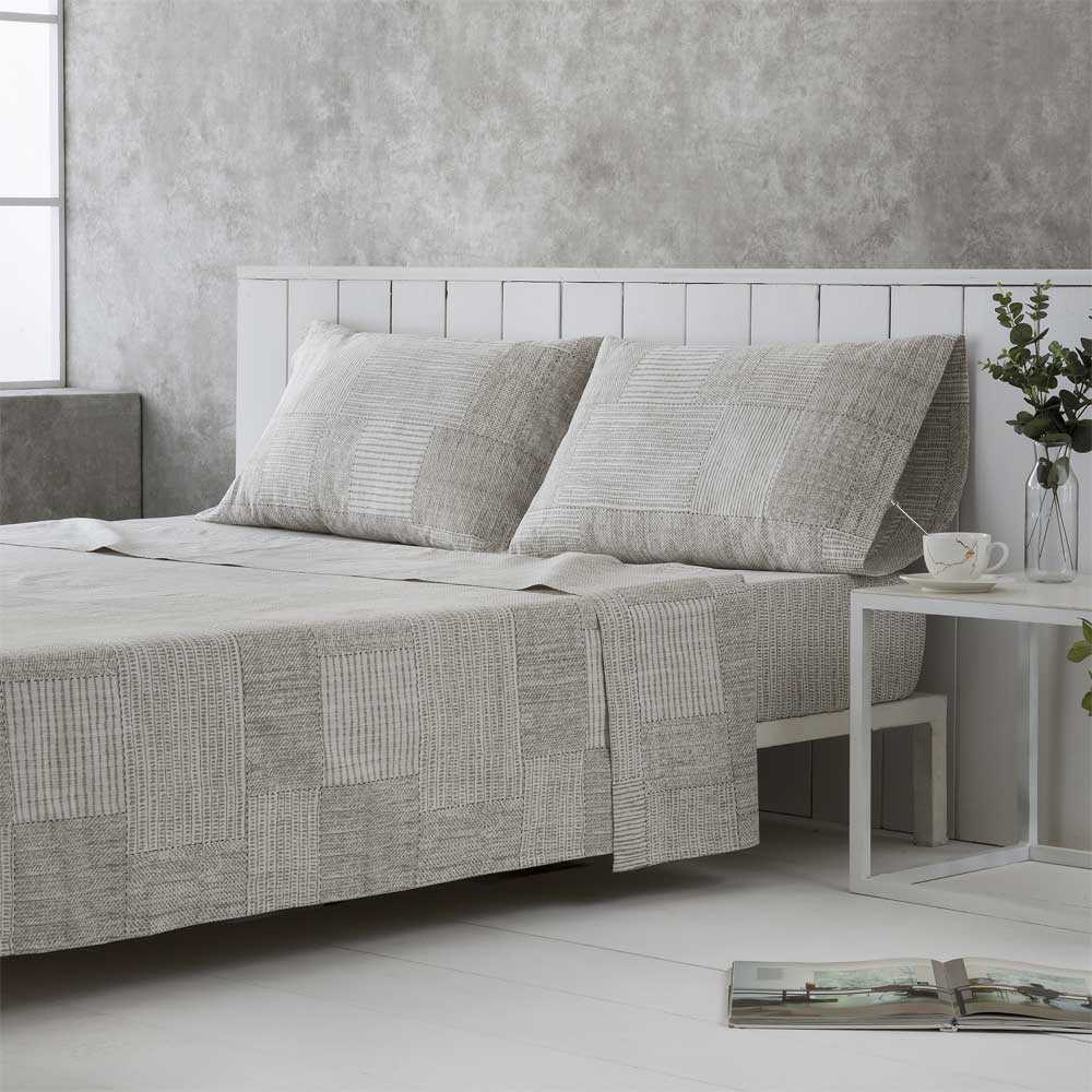 Ropa de cama gris y beige confeccionada en algodón orgánico de alta calidad, agradable al tacto y respetuosa con el medio ambiente.