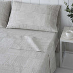 Sábanas gris y beige elaboradas en algodón orgánico, suaves, frescas y duraderas, ideales para un descanso cómodo y natural.