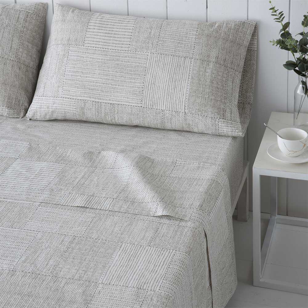 Sábanas gris y beige elaboradas en algodón orgánico, suaves, frescas y duraderas, ideales para un descanso cómodo y natural.