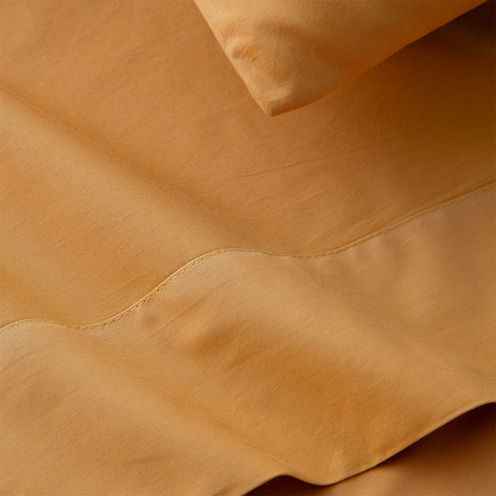 Conjunto de sábanas de percal de algodón de 200 hilos MOSTAZA compuesto por sábana encimera, bajera ajustable y funda de almohada, con acabado liso y elegante.
