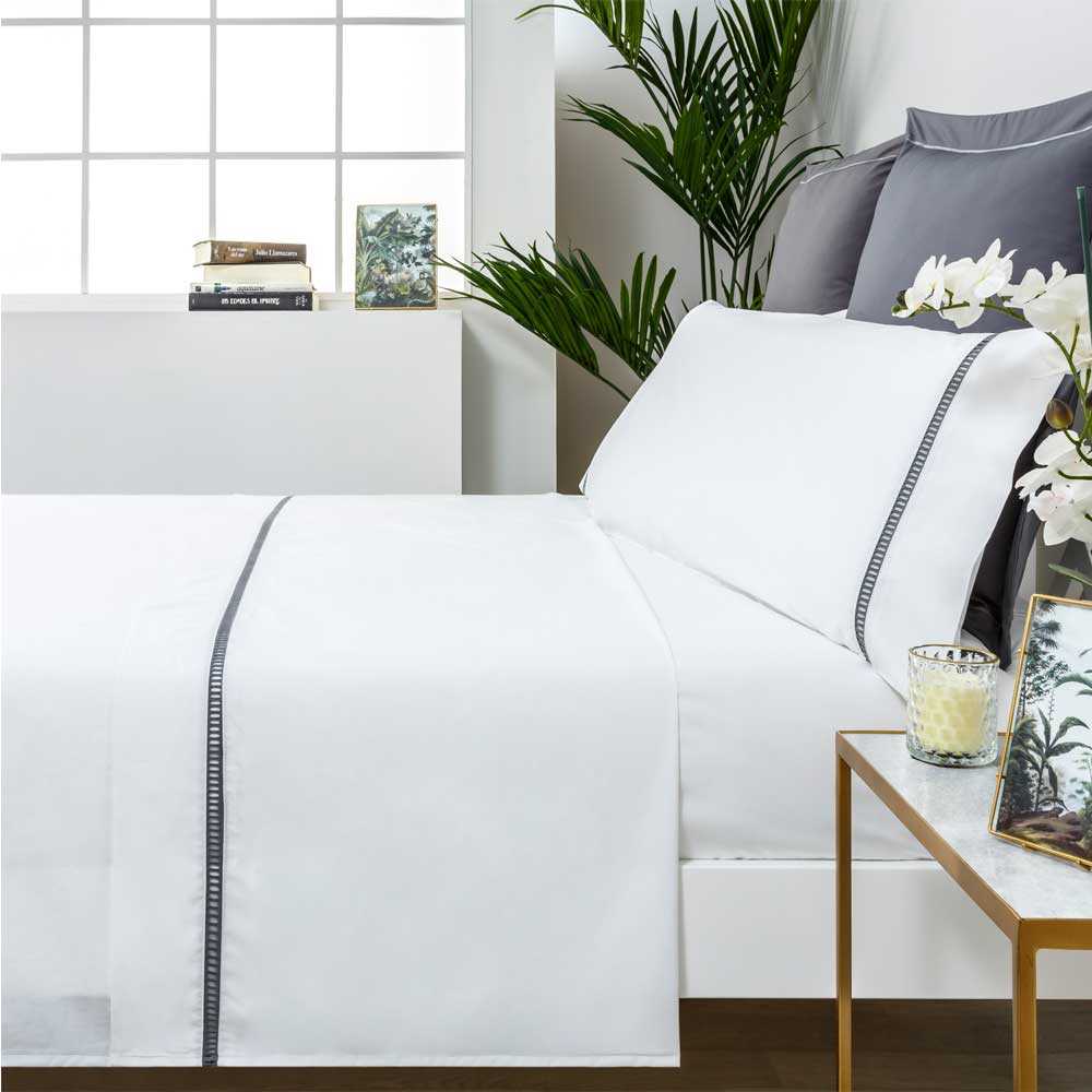 Sábana blanca de percal de algodón 200 hilos con elegante Vainica decorativa y acabado suave.