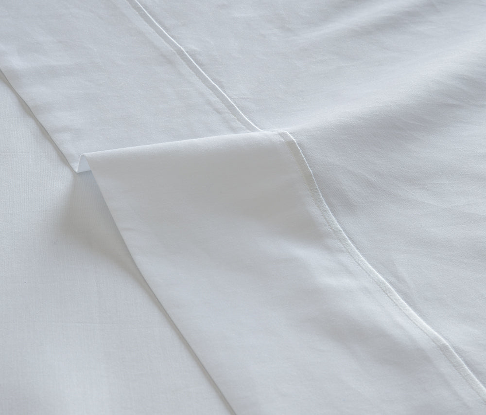 Juego de sábanas de satén blanco 300 hilos tejido premium en dormitorio moderno y luminoso